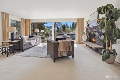 The attractive living room features floor to ceiling windows and a massive stone fireplace.