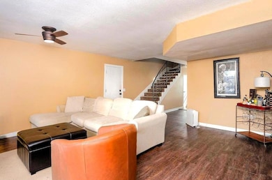 Living room with wood finished floors, stairway, a textured ceiling, and ceiling fan