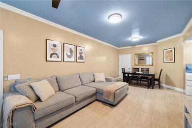 Living area featuring ornamental molding, baseboar