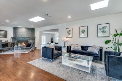 Living room featuring a brick fireplace, hardwood 