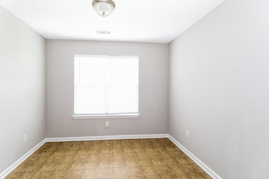 Spare room featuring baseboards and light tile patterned flooring