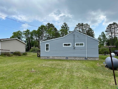 View of property exterior with a lawn and crawl space