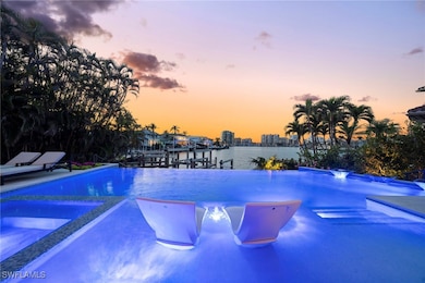 Pool at dusk featuring a water view and a dock