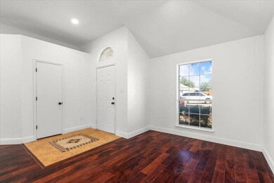 Foyer with hardwood / wood-style floors and vaulte