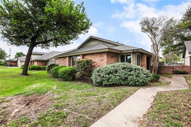 View of side of home with a lawn, fence, brick si
