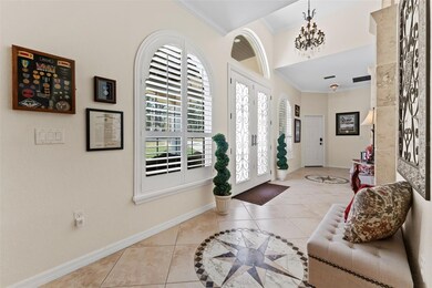Grand entry foyer features porcelain tile, plantation shutters and elegant fixtures