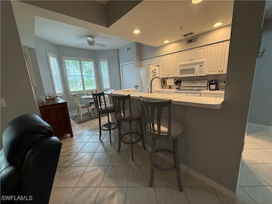 Kitchen featuring white appliances, a breakfast ba