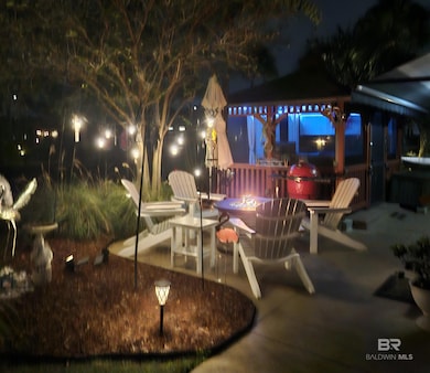 Patio at night featuring a patio area, an outdoor fire pit, and a gazebo