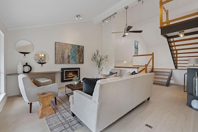 Living room featuring ceiling fan, light wood-sty