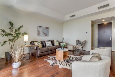 Living room with a tray ceiling, visible vents, cr
