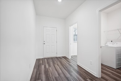 Foyer featuring washer / dryer and dark wood-type flooring