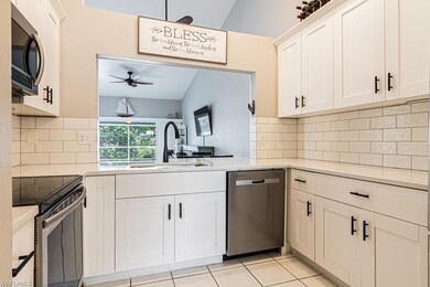 Kitchen featuring lofted ceiling, sink, white cabinets, and stainless steel appliances