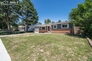 Ranch-style home featuring a front yard and a gara