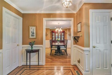 The foyer features oak floors with custom walnut i