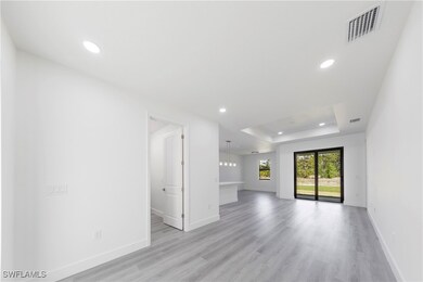 Unfurnished living room featuring a tray ceiling,