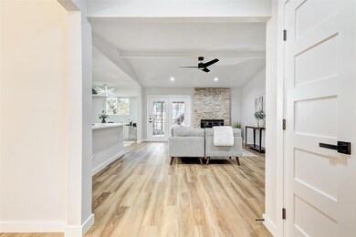 Living room featuring a ceiling fan, light wood f
