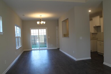 View of the great room, dining room and door leading to fenced back yard.