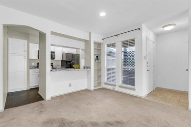 Carpeted spare room featuring arched walkways