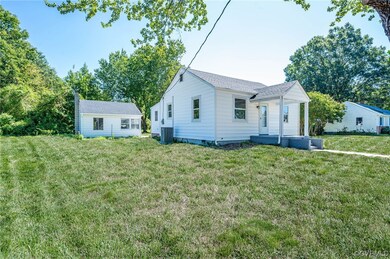 View of front of house with a front yard and central AC unit