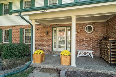 An aggregate concrete walk and covered porch lead 