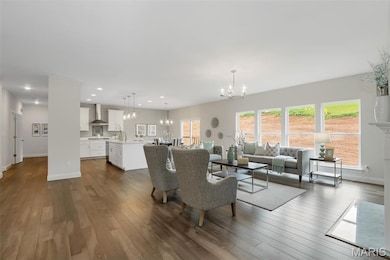 Living area featuring a chandelier, dark wood-style flooring, and recessed lighting