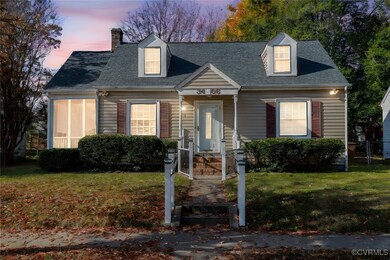 Cape cod home with covered porch and a lawn