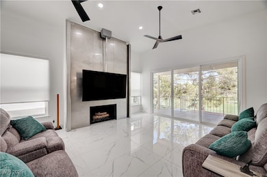 Living room with a ceiling fan, marble tiled floor