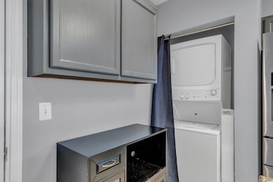 Washroom featuring stacked washer / drying machine