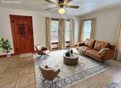 Living area featuring a textured ceiling, a ceiling fan, light tile patterned floors, and baseboards