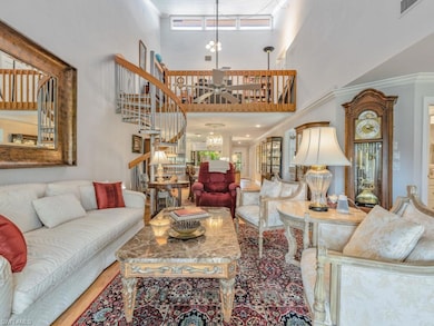 Living room featuring stairs, a towering ceiling, wood finished floors, crown molding, and ceiling fan