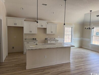 Kitchen featuring white cabinetry, a center island