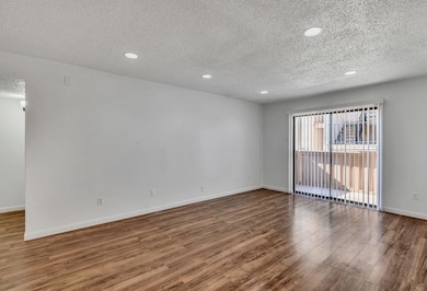 Spare room featuring a textured ceiling and hardwo