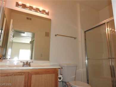 Bathroom with toilet, a shower with shower door, a