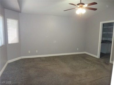 Spare room with lofted ceiling, dark colored carpe