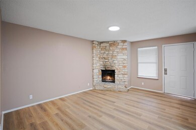Unfurnished living room featuring baseboards, a t