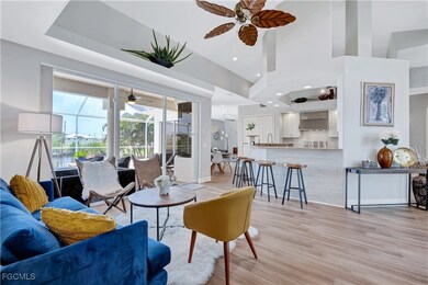 Living room with light wood-type flooring, a high ceiling, recessed lighting, and a ceiling fan