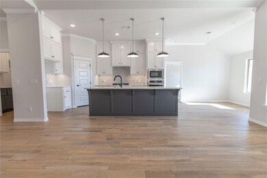 Kitchen with a kitchen island with sink, white cab