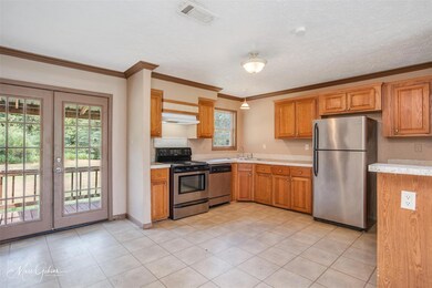Kitchen featuring a textured ceiling, light tile p