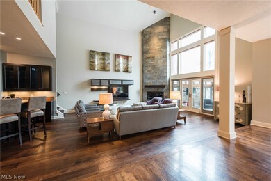  Incredible Great Room with hard wood floors, Bar with wine and beer coolers, floor to ceiling slate gas fireplace, and double doors that lead to Enclosed Patio.