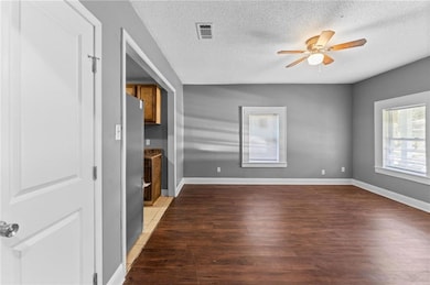 Spare room featuring light wood finished floors, a textured ceiling, and a ceiling fan
