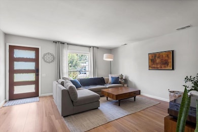 Living area with light wood-type flooring and bas