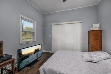 Bedroom with crown molding, ceiling fan, and dark 