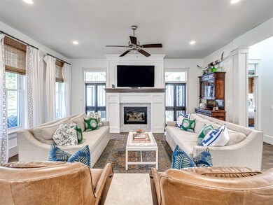 Living room featuring dark wood-type flooring, plenty of natural light, and ceiling fan