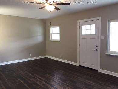 FRONT DOOR ENTERS INTO LARGE LIVING ROOM WITH WOOD