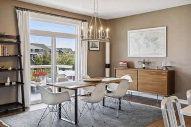 The informal dining room is adjacent to the kitchen. It features a chandelier and sliding door access to the deck.