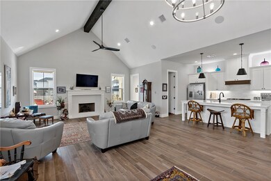 Living room with ceiling fan with notable chandeli