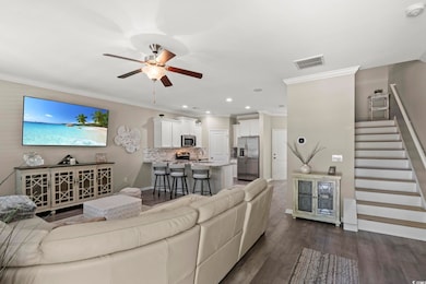 Living area featuring ceiling fan, stairs, visible