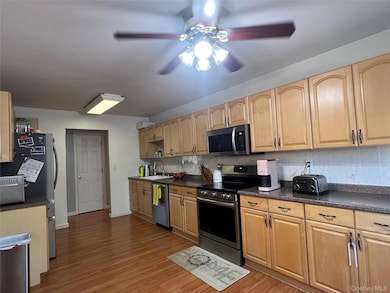 Kitchen with dark countertops, stainless steel appliances, and backsplash