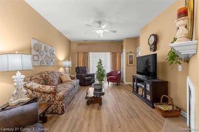 Living room with light wood-style floors and ceiling fan