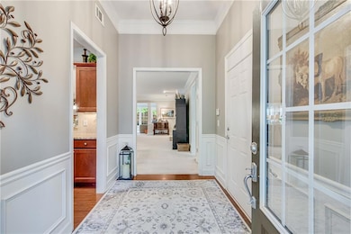 Foyer featuring ornamental molding, dark wood-styl